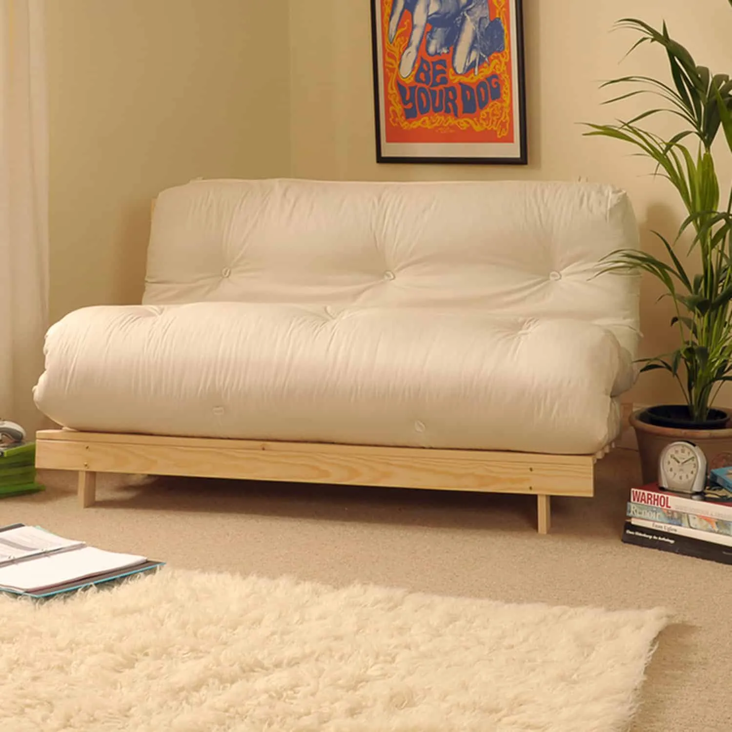 futon furniture, plants, wall hangings, white mattress, fur rug
