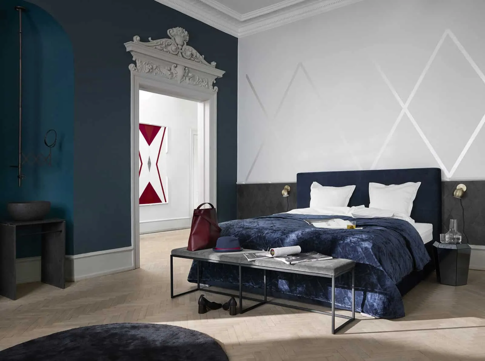 bedroom furniture with white pillows, blue sheets, dark blue and white walls, side table