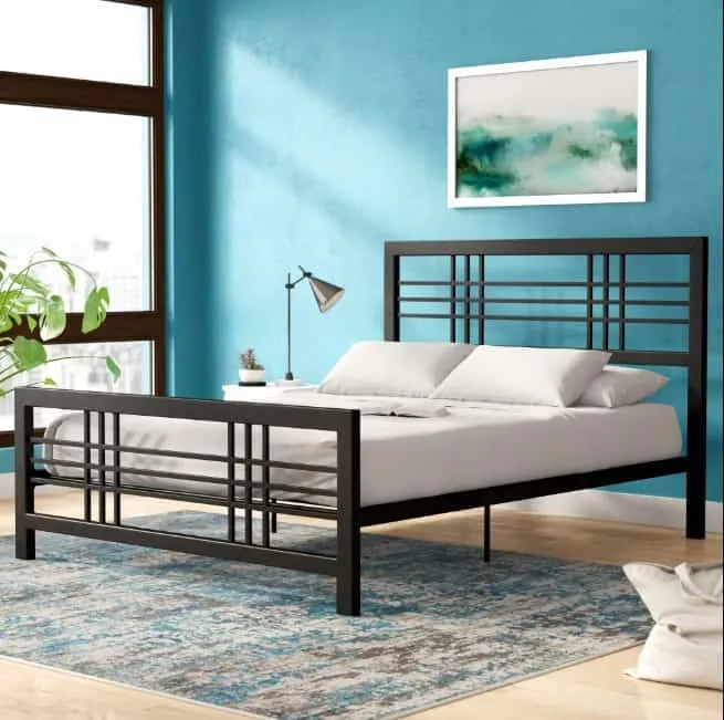 black open frame double bed with white pillows and sheet,blue walls