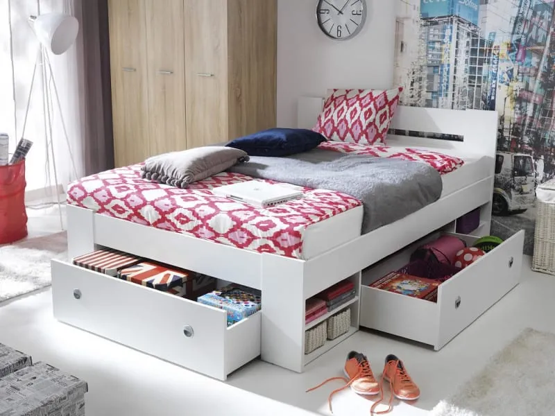 white storage bed with drawers, wall clock, pink and white bedsheet, pillows