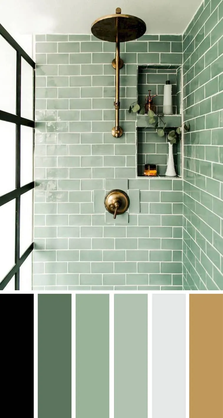 A bathroom with aqua tiles and gold shower fixtures
