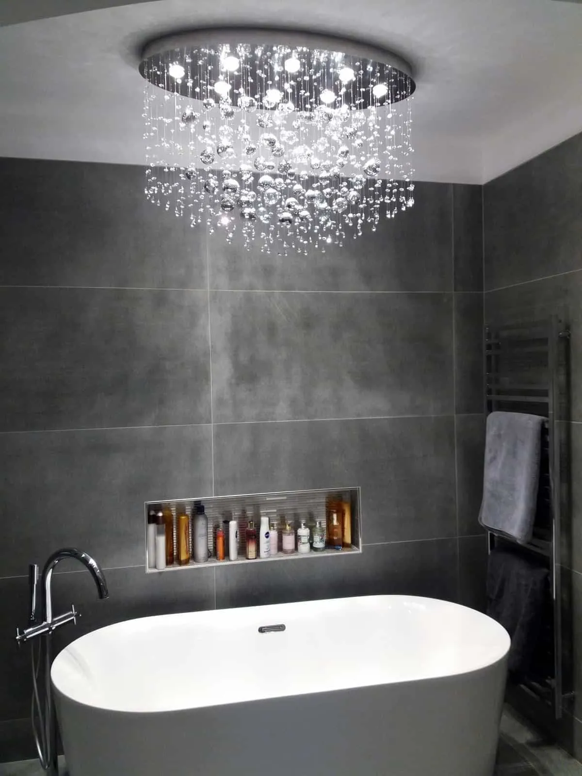 Crystal chandelier above bathtub in bathroom
