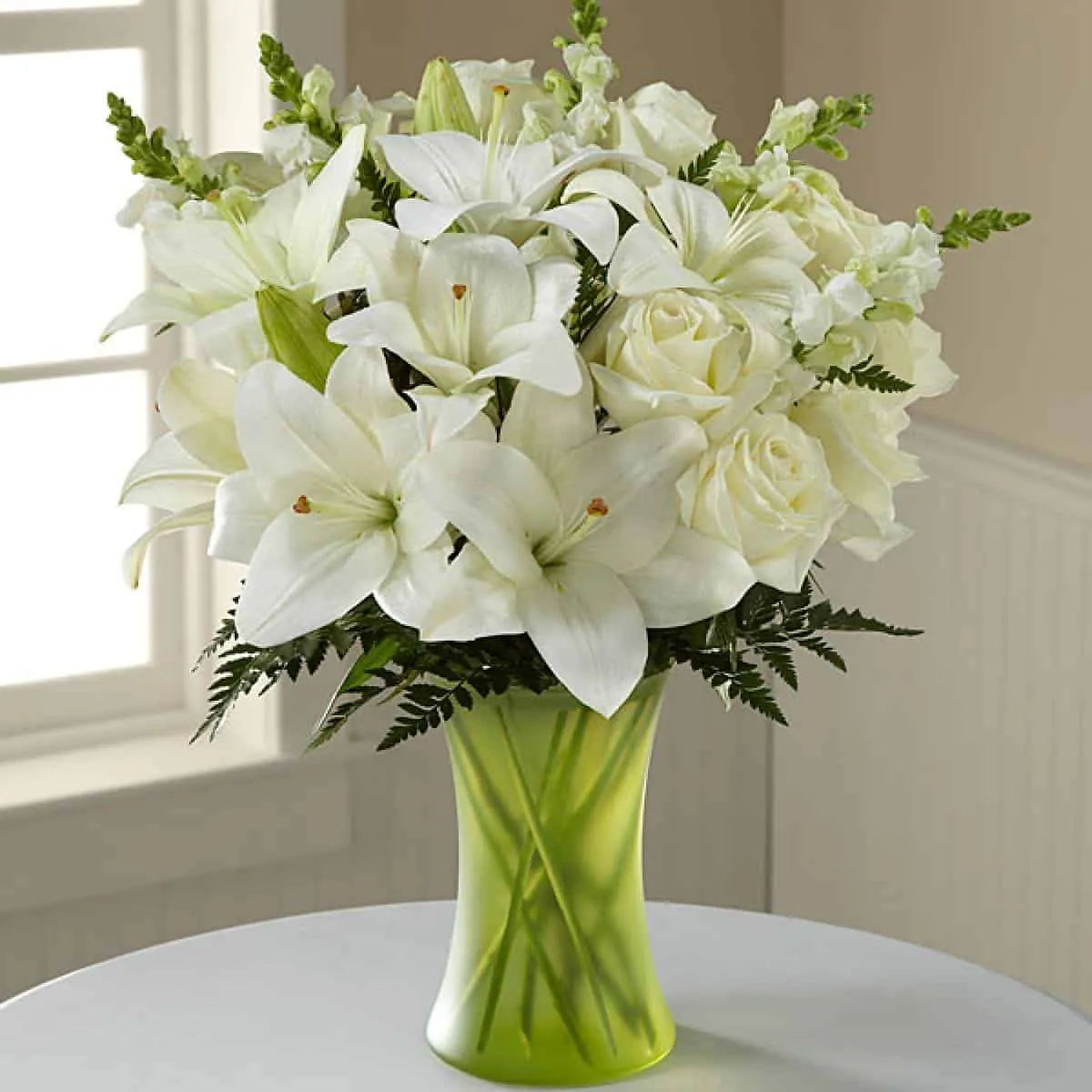 white lily flowers in a green vase
