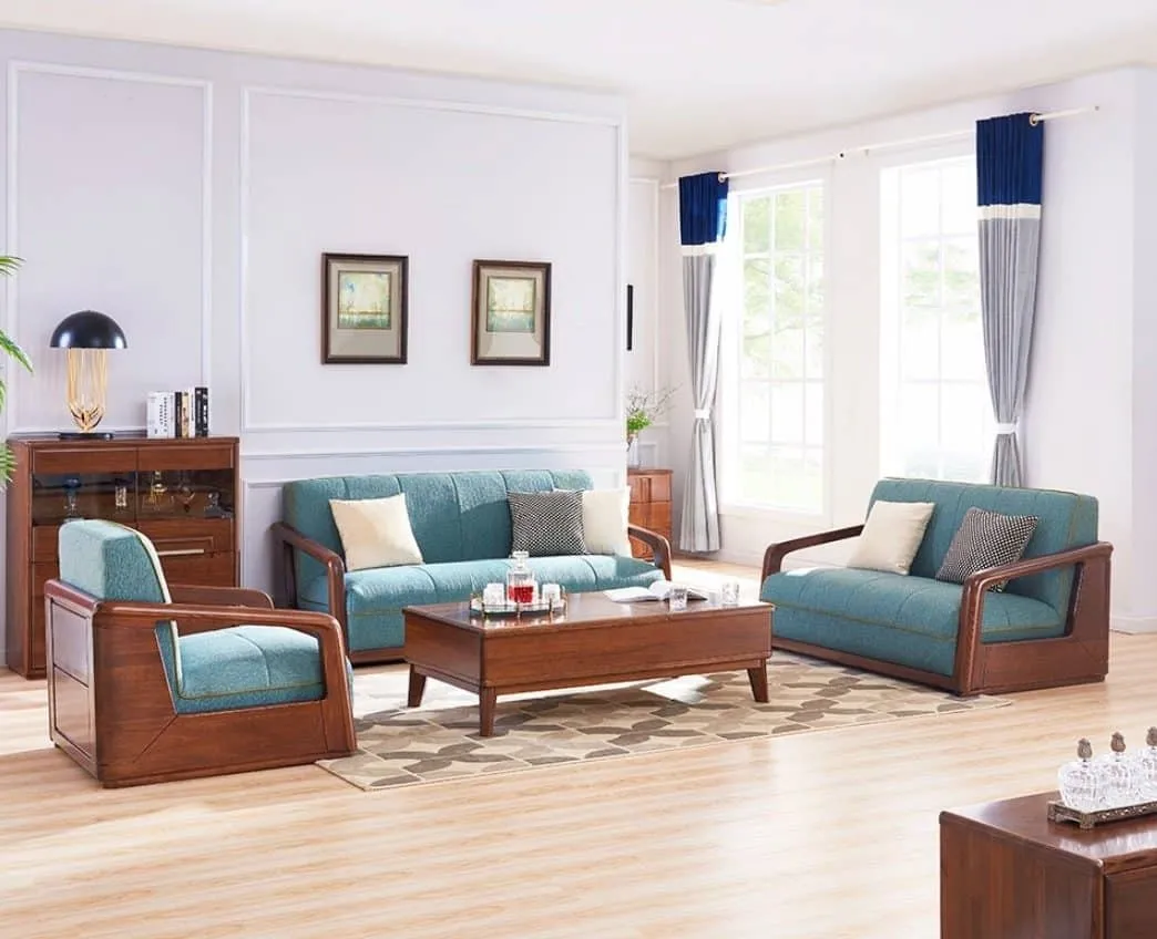 brown sofa with blue cushions in a living room with table and wall paintings