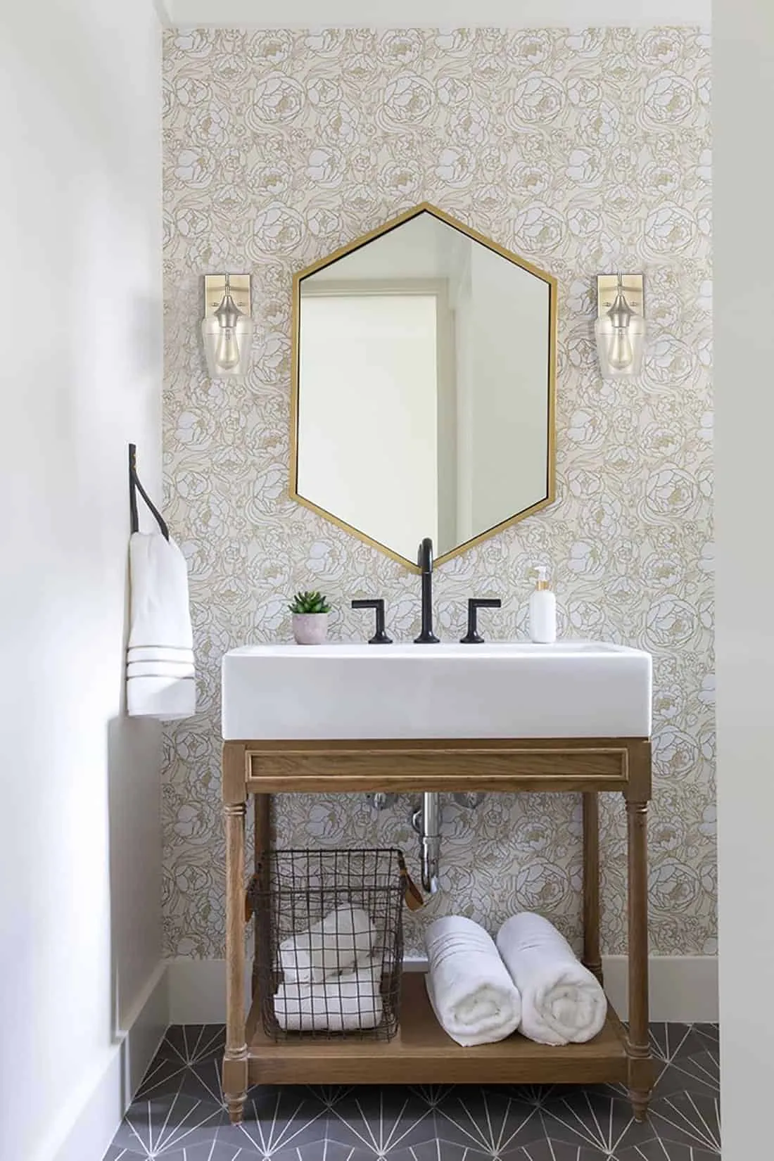 bathroom vanity with wall scones and hexagonal mirror
