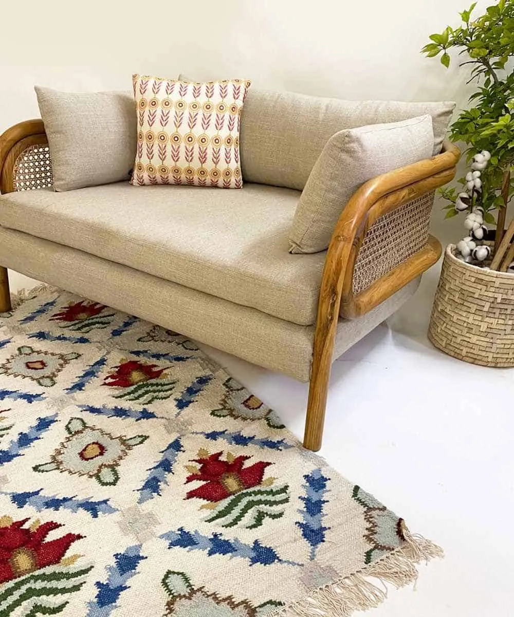 wooden seating with beige cushions and multi coloured rug 
