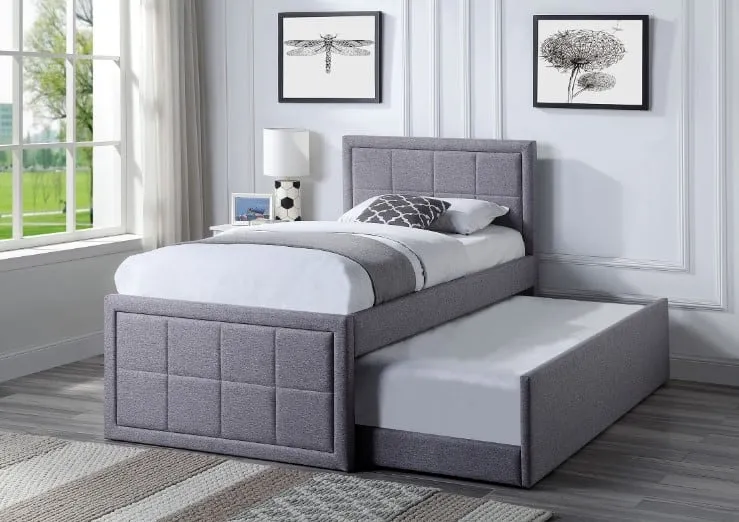 grey trundle bed with white bedsheet, wall hangings