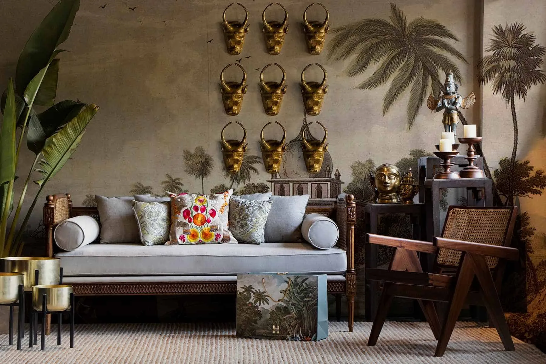 brown interiors of a living room with light blue sofa, plants and eccentric wall hanging art