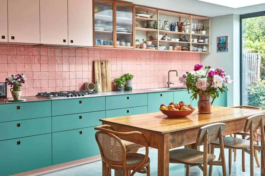 A brightly coloured modern kitchen area with best furniture and tiles.