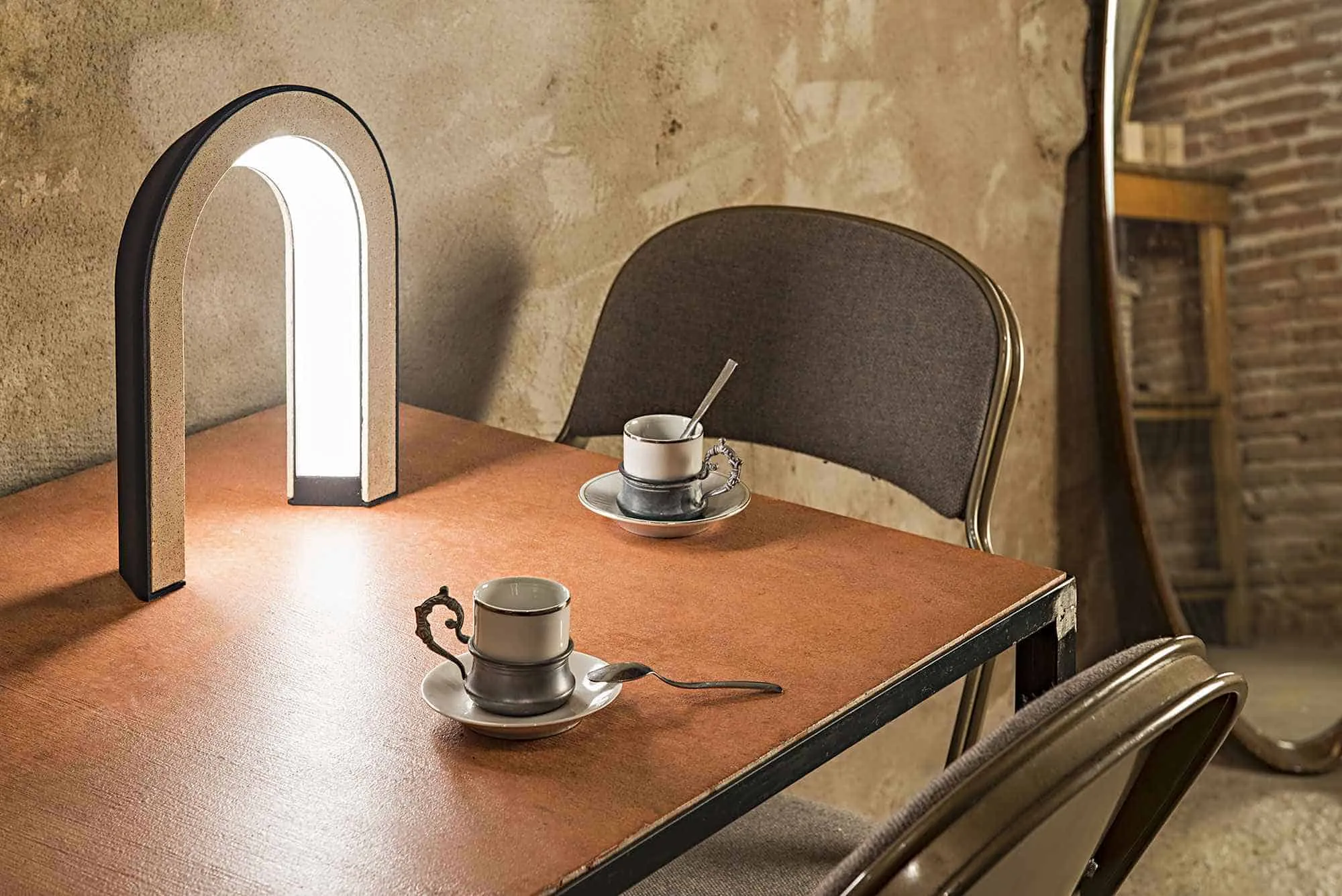 brown table with chairs, tea cups and light