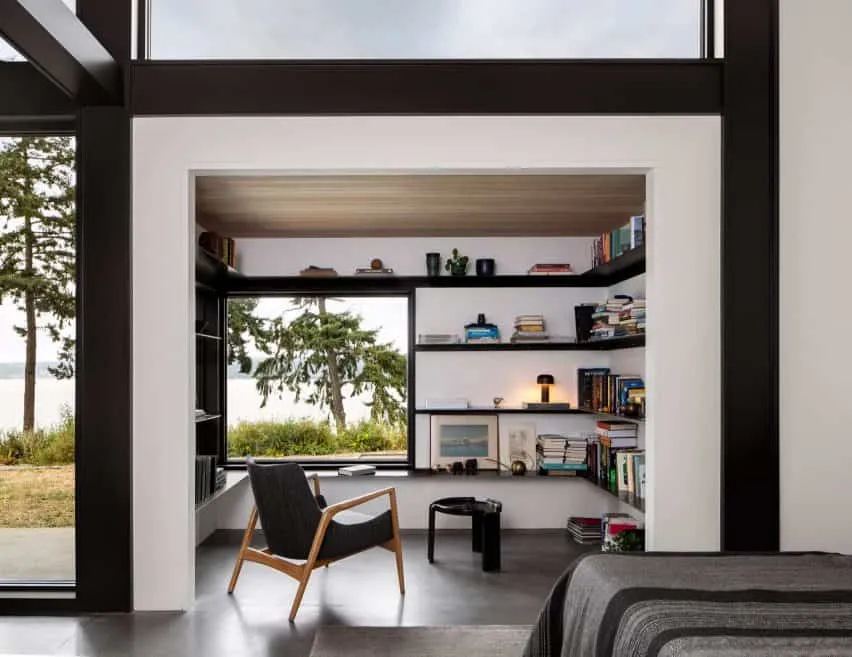 a room with black chair, shelf and table