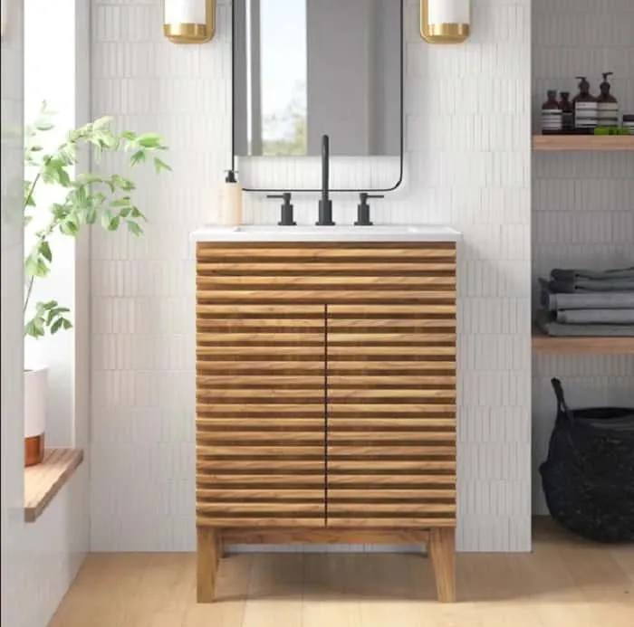 fluted wooden dresser with white walls and ample natural lighting and greens in this bathroom