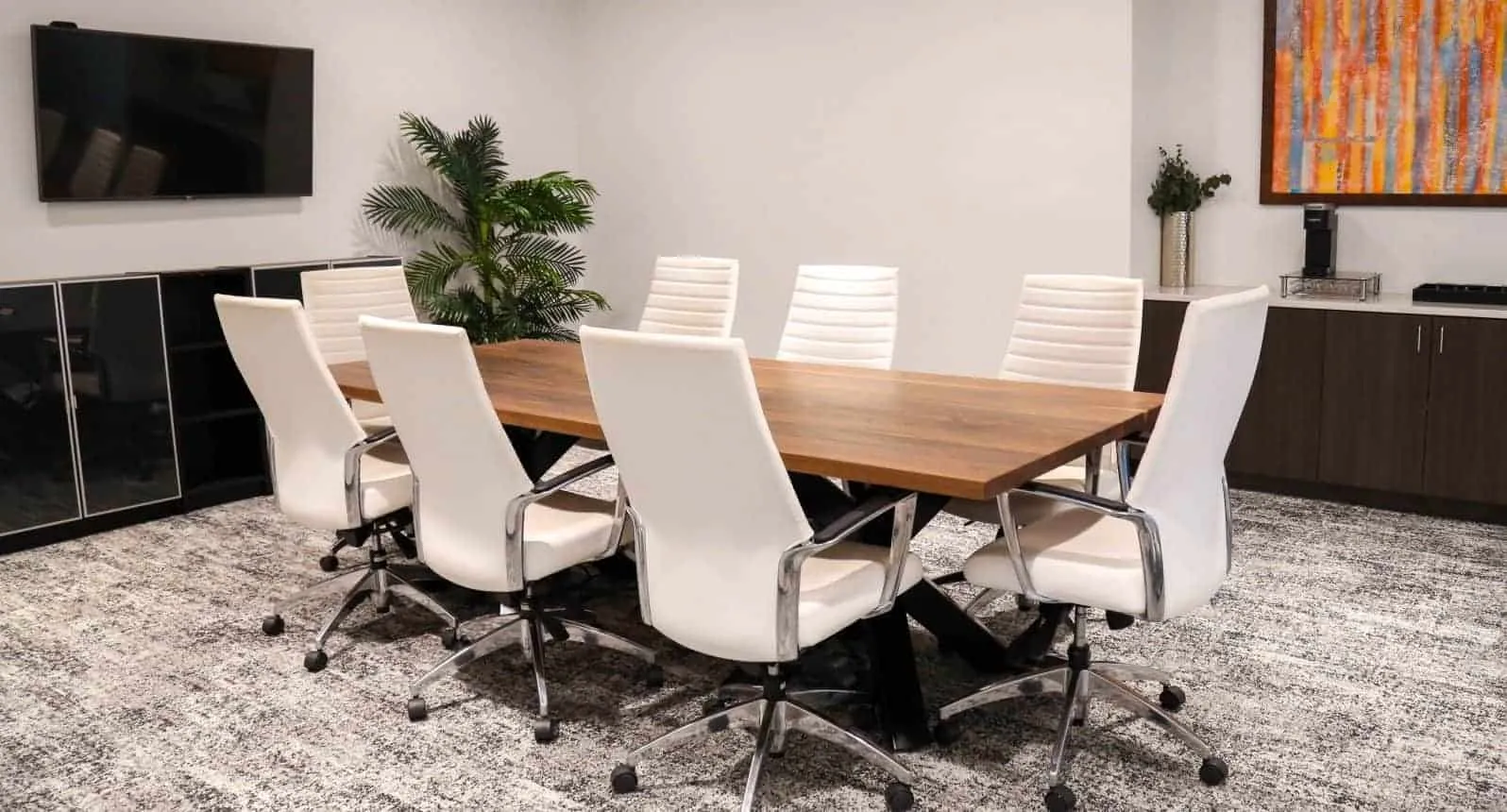 8-seater wood conference table with white ergonomic chairs