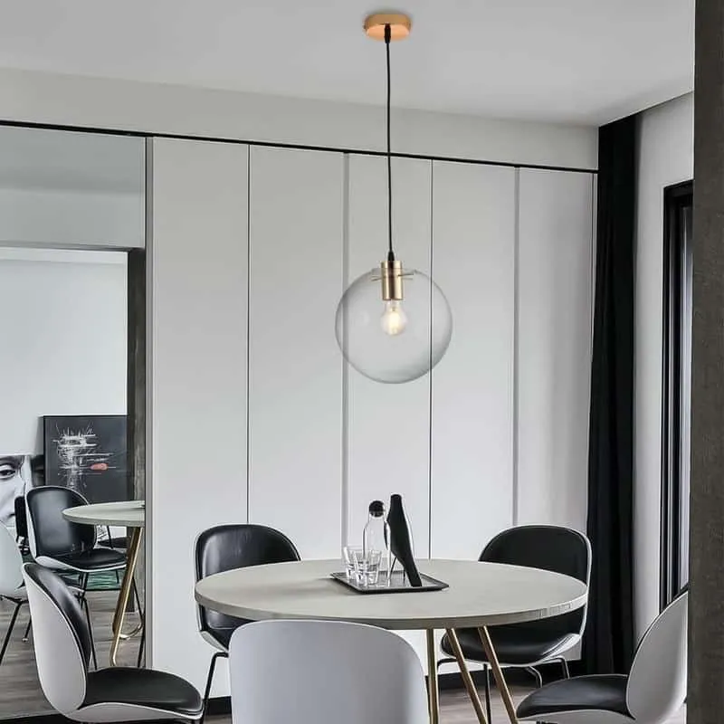 white dining table with black chair and pendant light