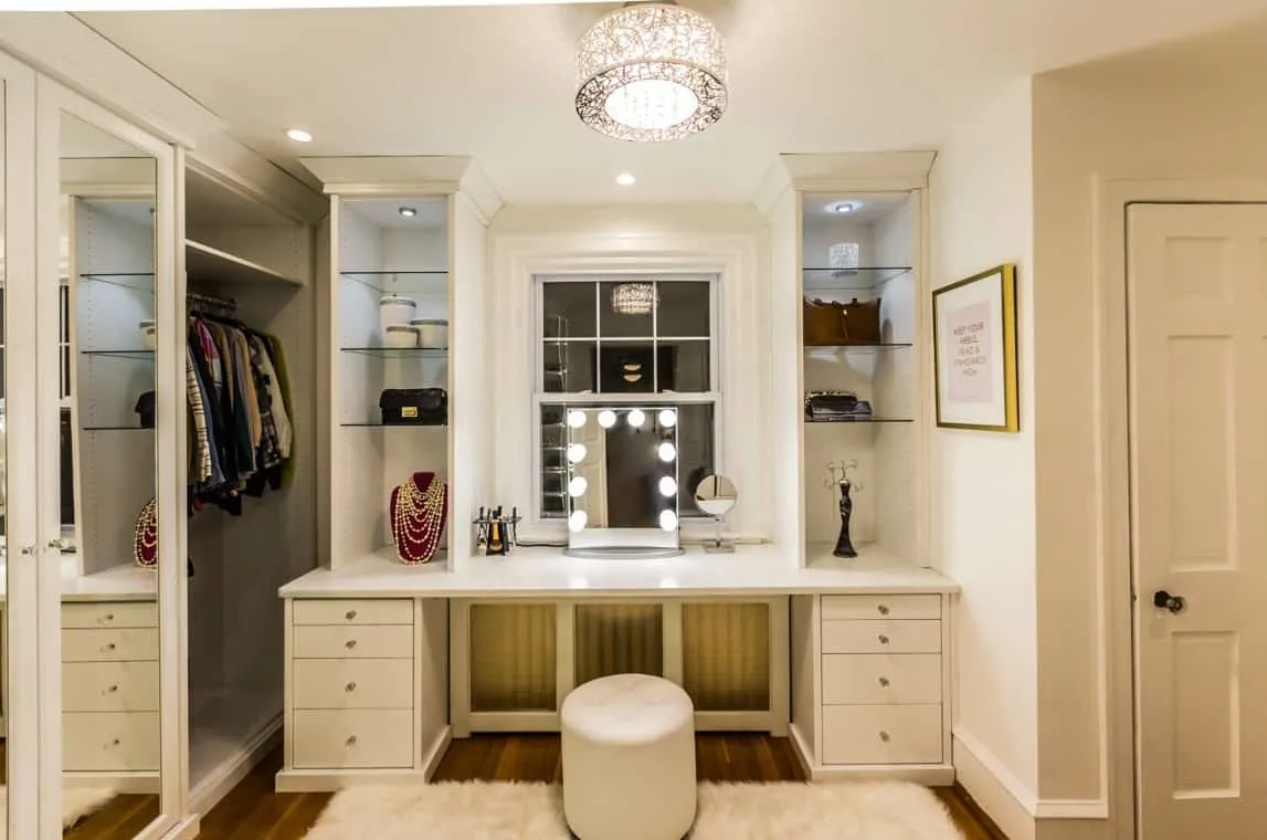 cream vanity in the wardrobe with a leatherette white pouffe