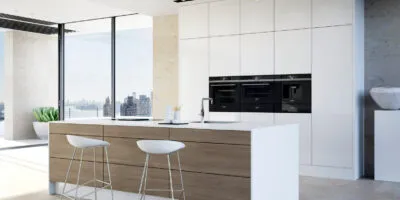 white coloured minimalist kitchen design with built in appliances, white cabinetry, and light brown island with seating