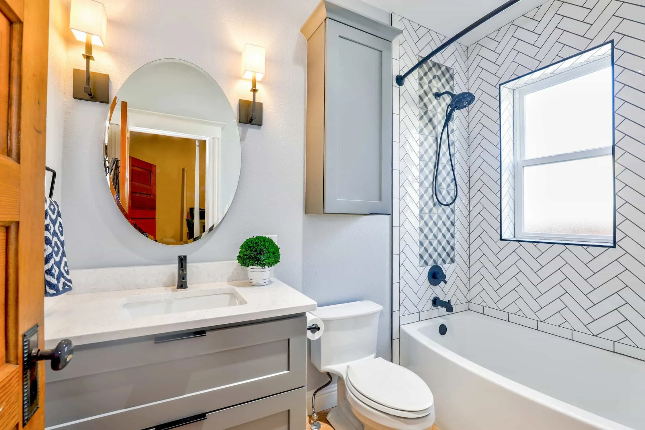 All white small restroom, with bathtub, mirror, shelf