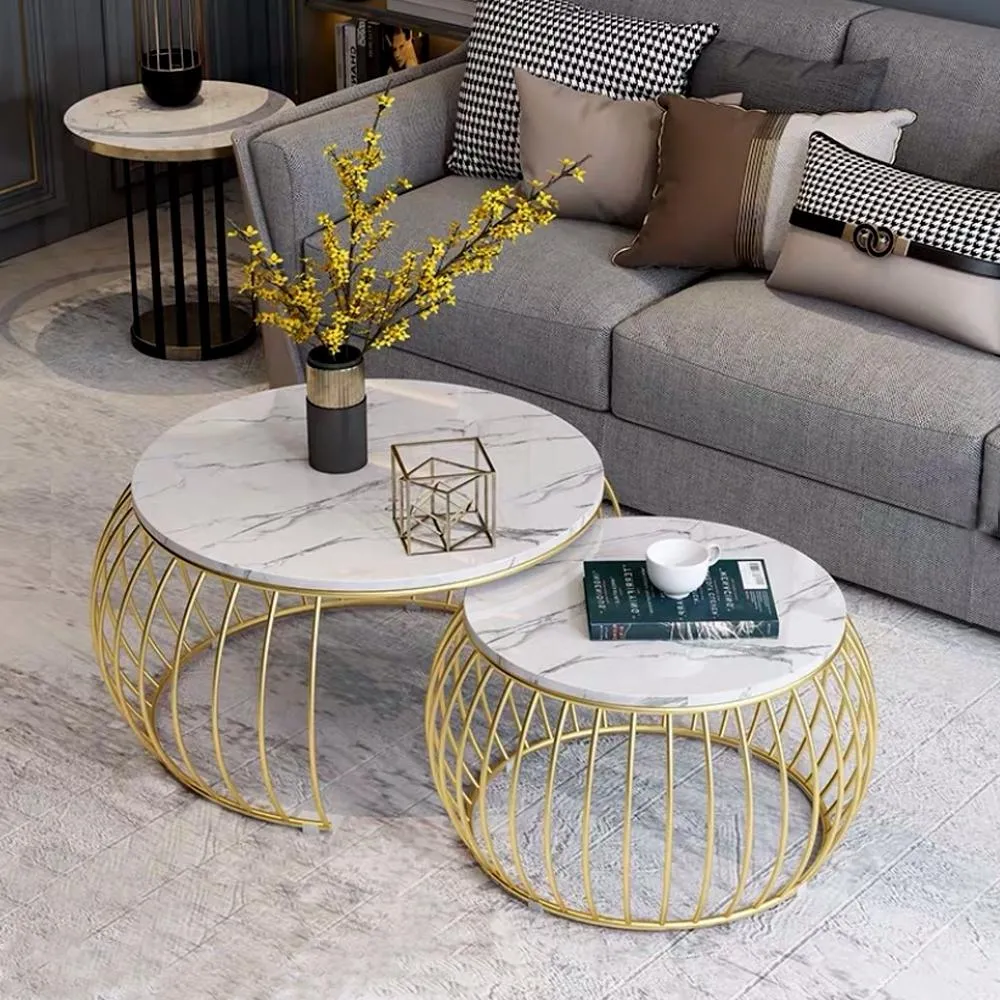 beautiful centre piece with gold faux caged body, white marble table top, grey sofa, grey tiled floor, cushions, book on table top, artificial flower decorative piece