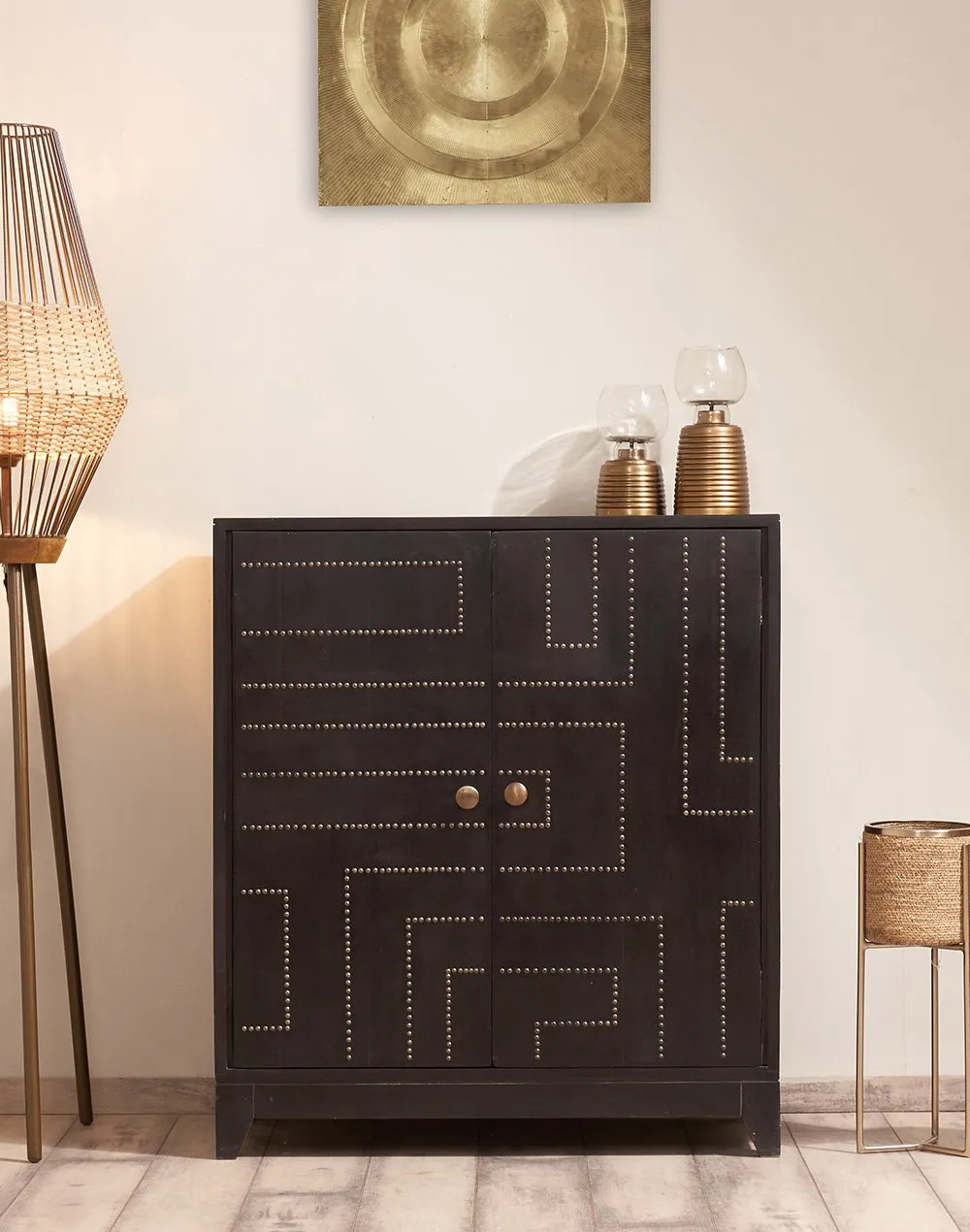black wood closed cabinet to store your footwear, placed in a living room with decor pieces on the top, a floor lamp placed besides the furniture, white walls, painting hanging on the wall