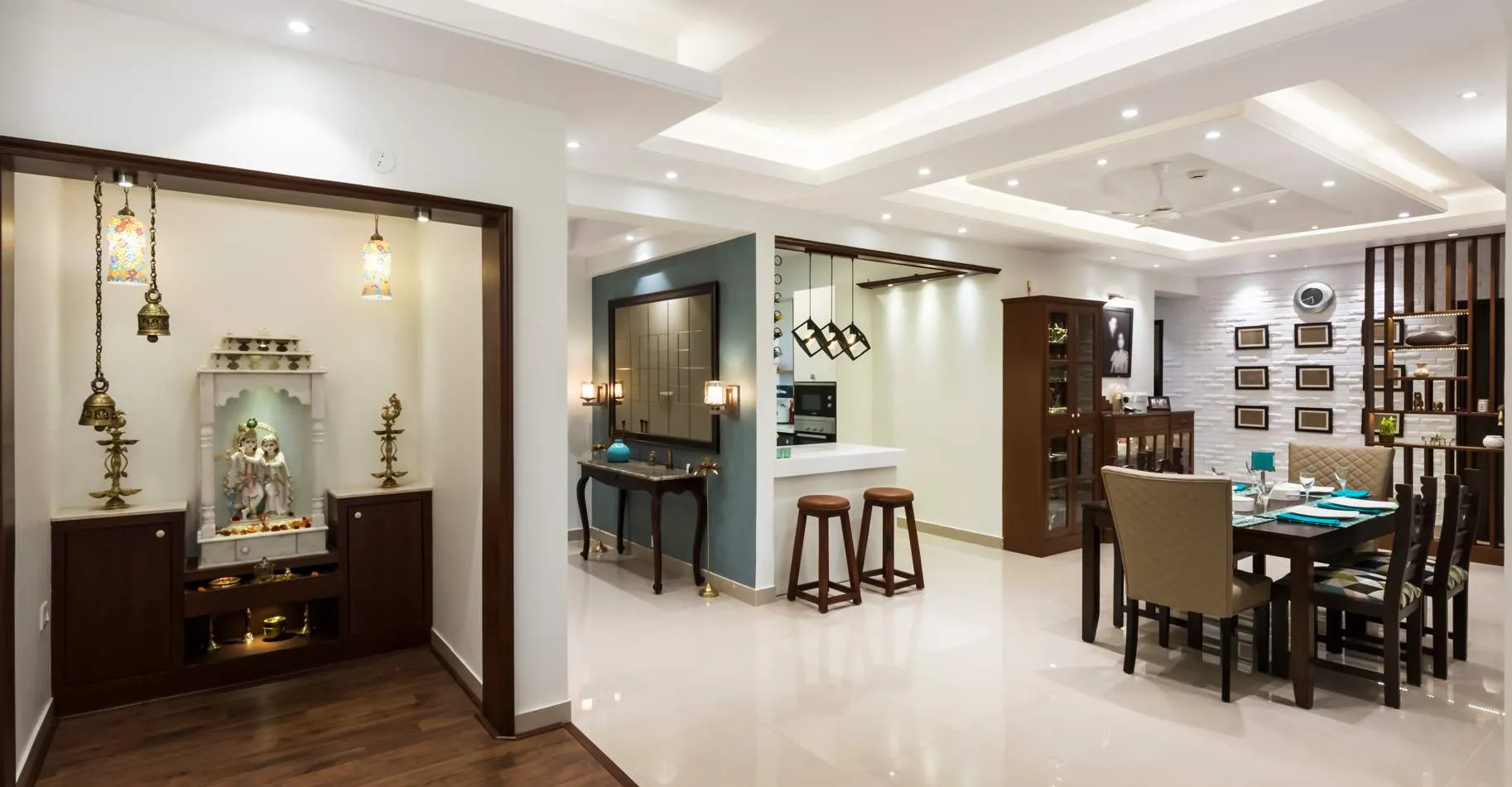 white home interiors with a pooja room, dining rom and kitchen with dining table, chairs, pendant lights and ceiling lights