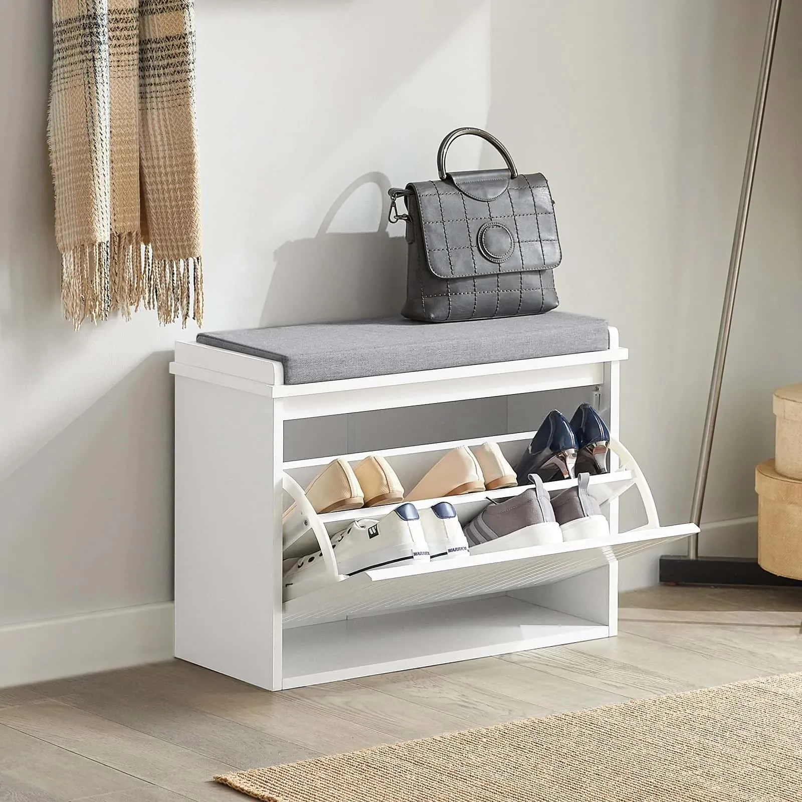 shoe rack with comfortable cushion seating, wall painting, grey bag on the rack