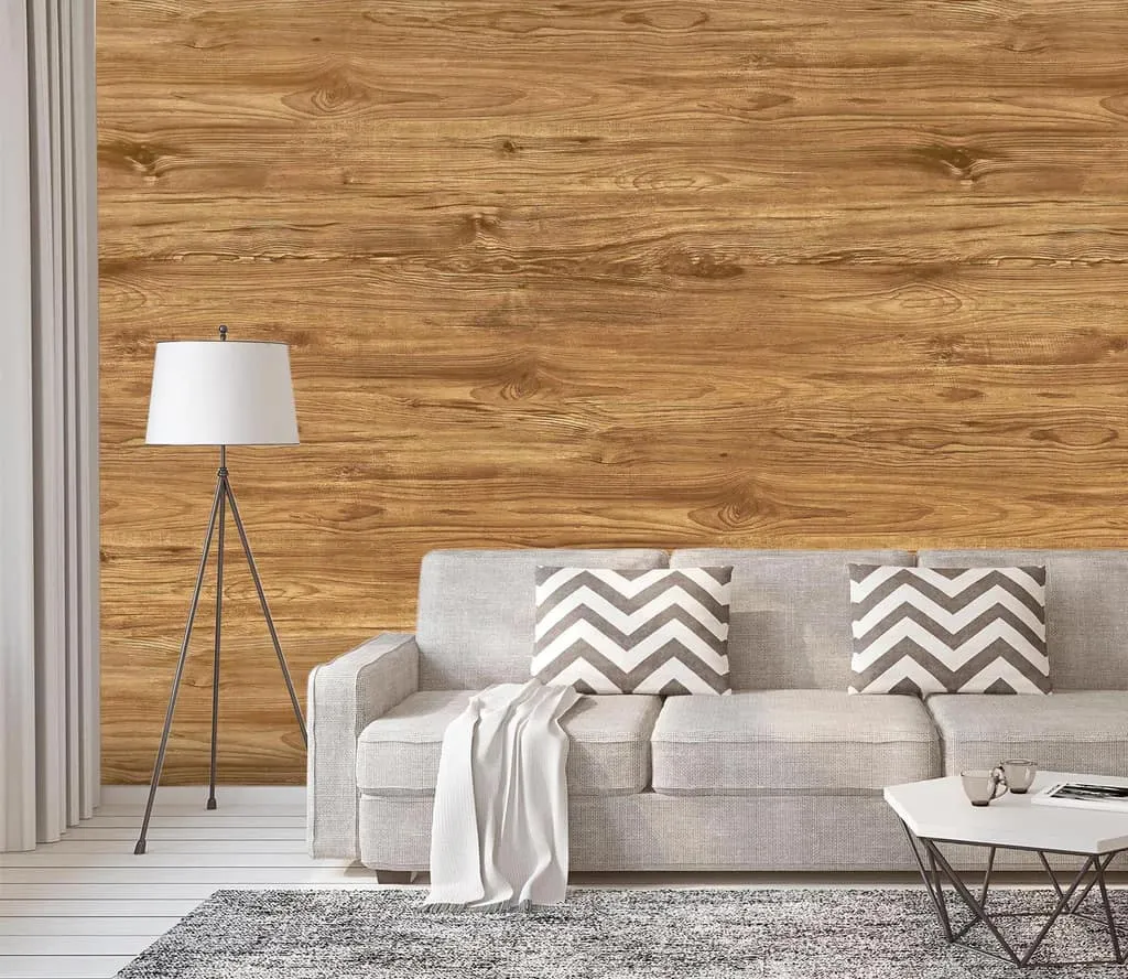 A wall with wooden texture and a grey coloured sofa.