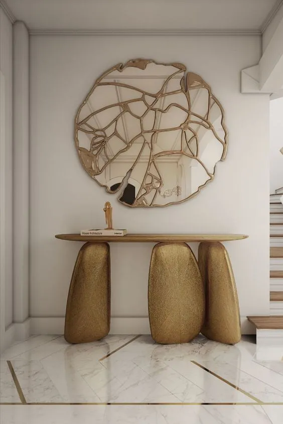 luxurious sculptural console table, with a designer mirror hanging above the furniture piece