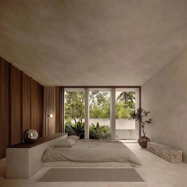 white bedroom with brown accent wall, glass doors, bed, brown rug, and indoor plant