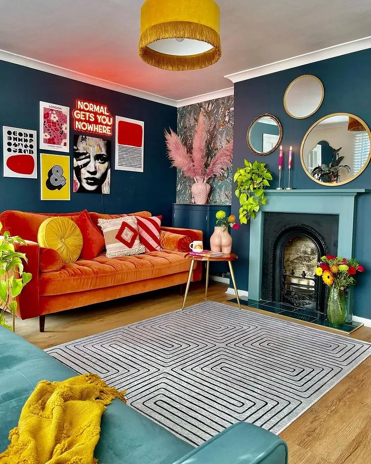 blue living room with mirrors, orange sofa, white rug, wooden flooors, and picture gallery, 