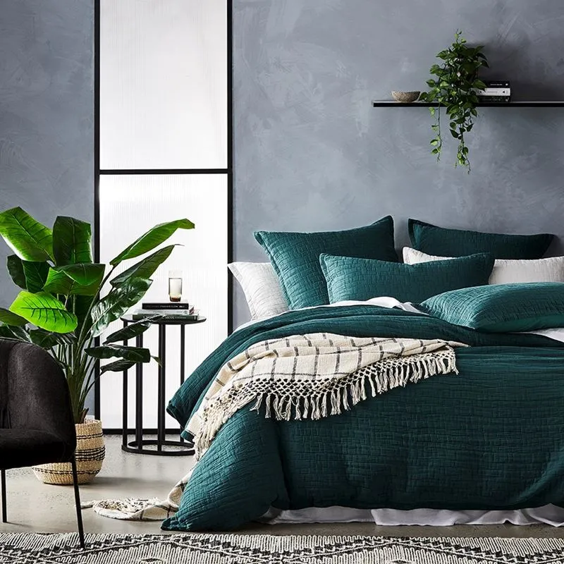 grey bedroom with plant, bed, and side table
