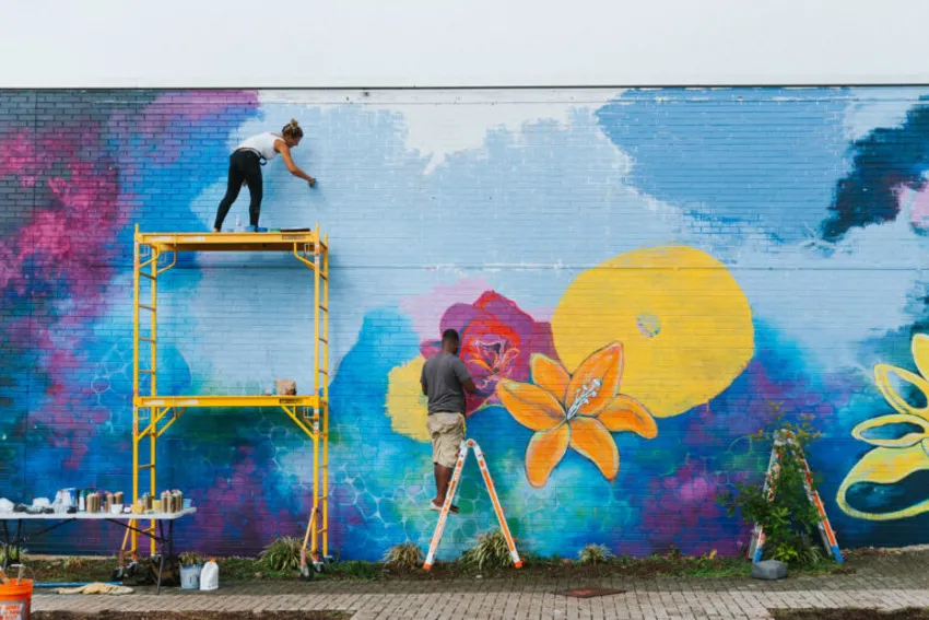 Two artists giving finishing touch to the wall art