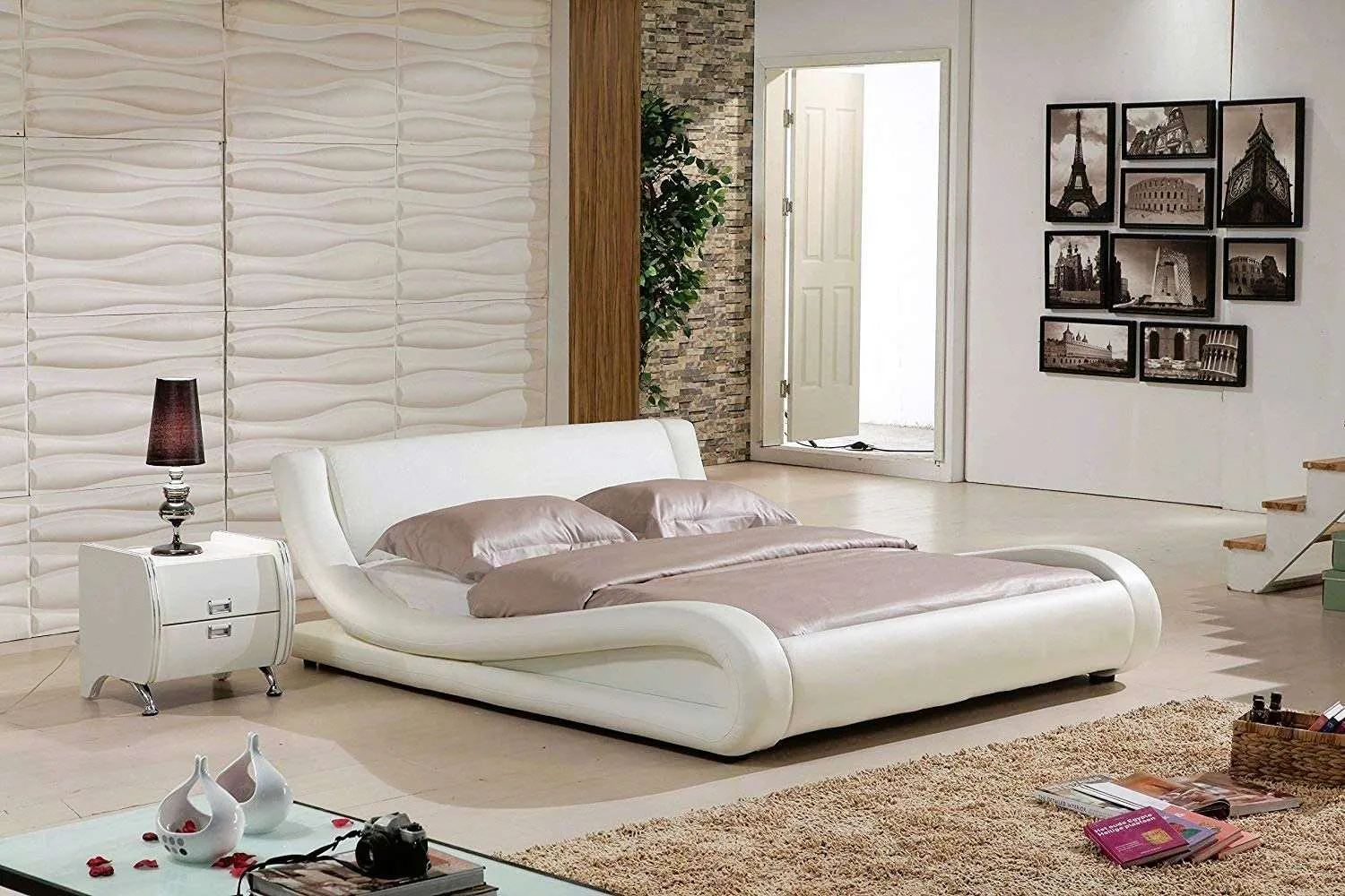 white bedroom with a low height modern wood double bed design bed with a rug, white table, table lamp and plants