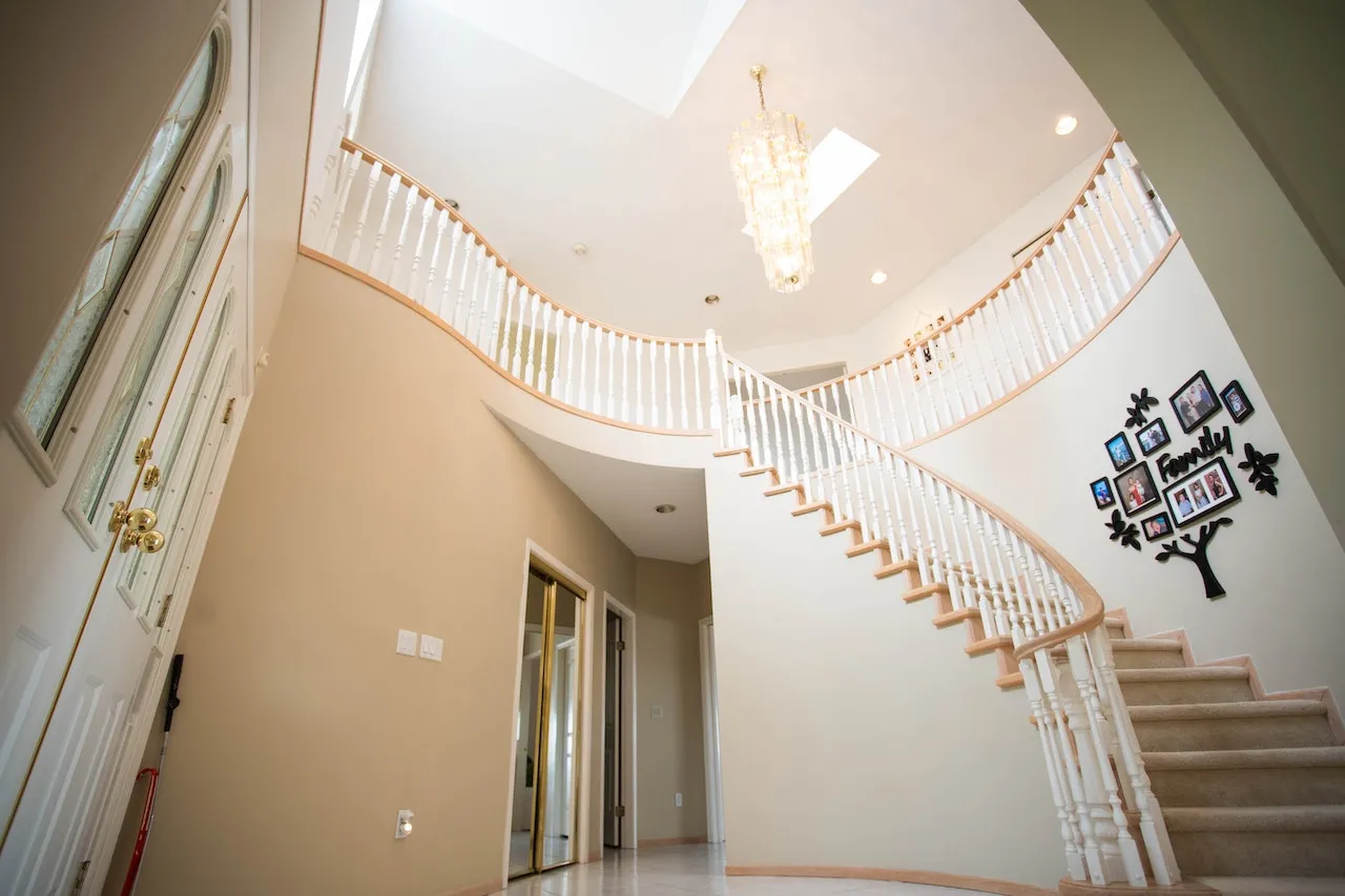 Helical stairs spiraling upwards, adding elegance and flow to the space in the white and beige background, small space stair ideas