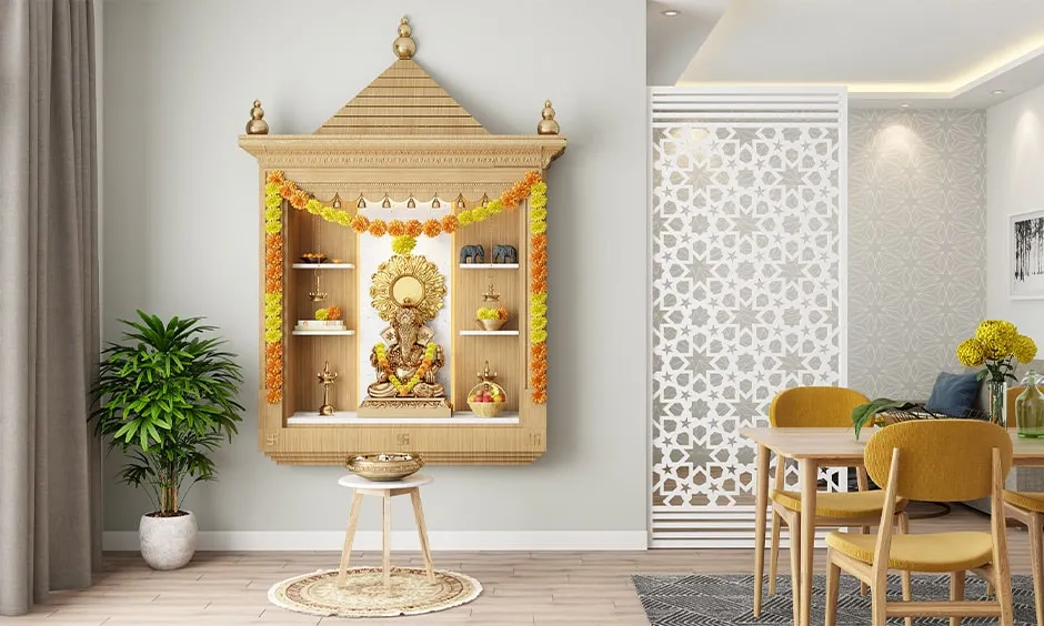 A pooja room with grey imprints on wall a plant a mandir and a chair