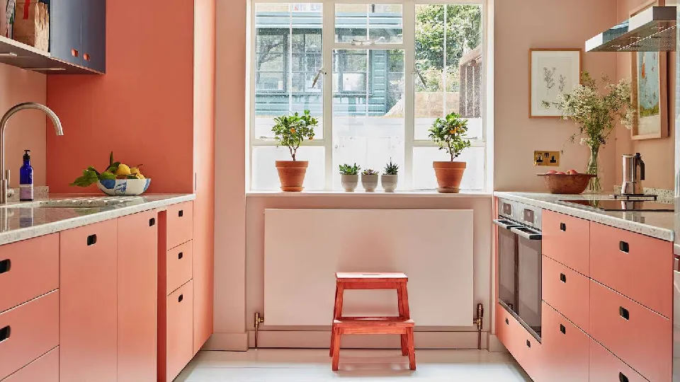 A bright kitchen in peach color with open windows, small modern kitchen ideas