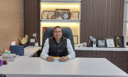 Mr. Jagdish Agarwal of Rajasthan Lime Udyog a sanitaryware, bathroom fittings and stiebel eltron dealers in Guwahati sitting in his office with a white desk, chair, awards and decorative items