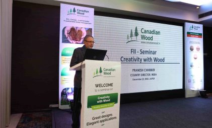 Mr. Pranesh Chhibber, Country Director, Canadian Wood at the seminar in Jaipur in a hall with black floors and white podium promoting creativity with seasoned wood species in manufacture and construction